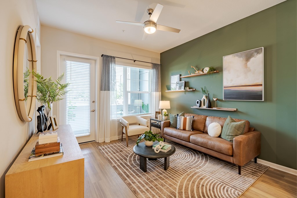 A living room with a brown couch, a coffee table, and a painting on the wall.