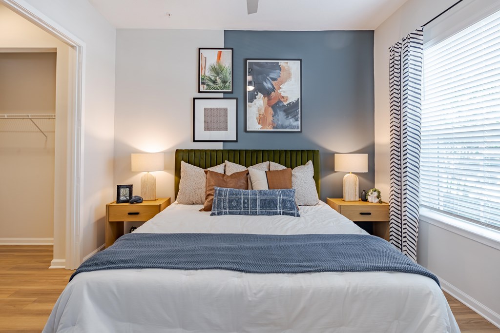 A bedroom with a large bed and a green headboard.