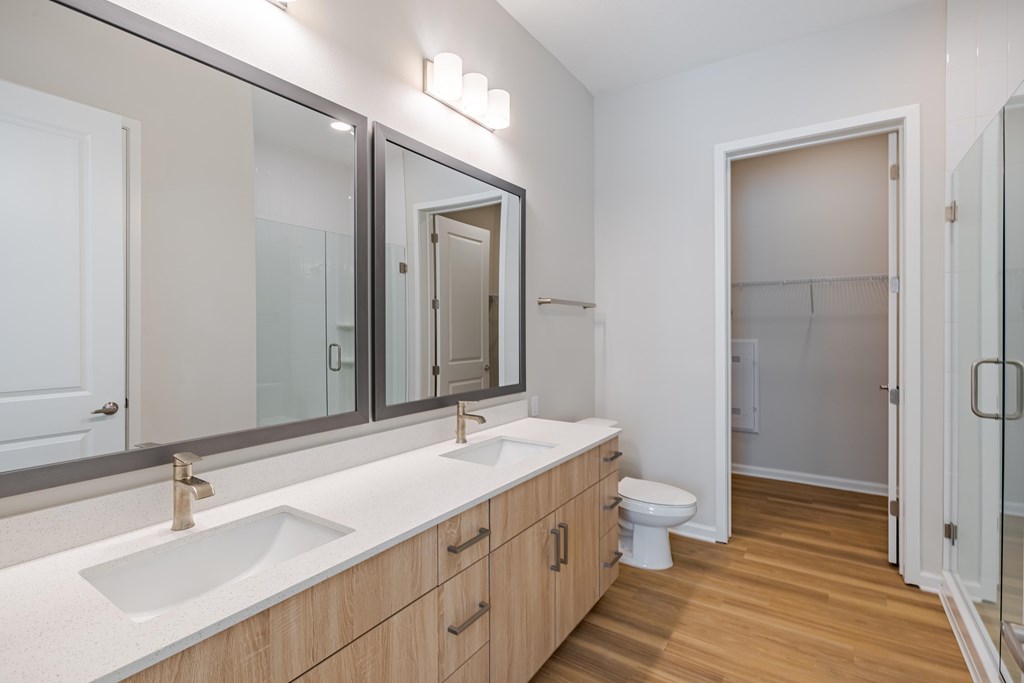 A bathroom with a white countertop and wooden cabinets.