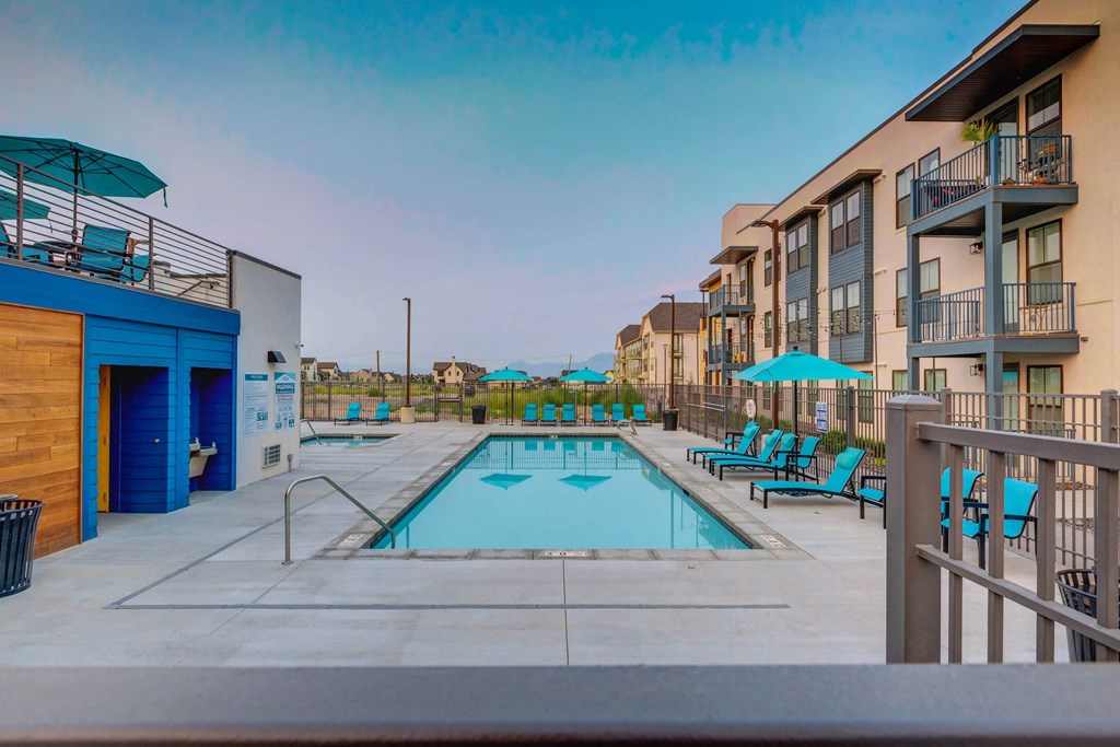 our apartments have a pool and a building with chairs and umbrellas