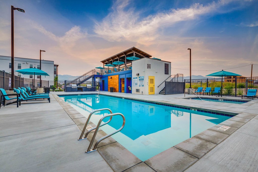 a swimming pool with a building in the background at dusk