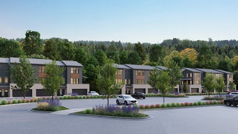 A modern building complex with a parking lot in front.