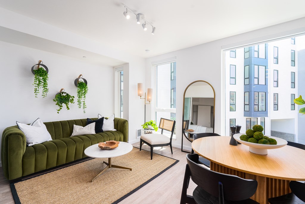 a living room with a green couch and a large window
