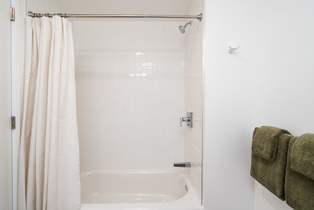 a bathroom with a white tub and a white shower curtain