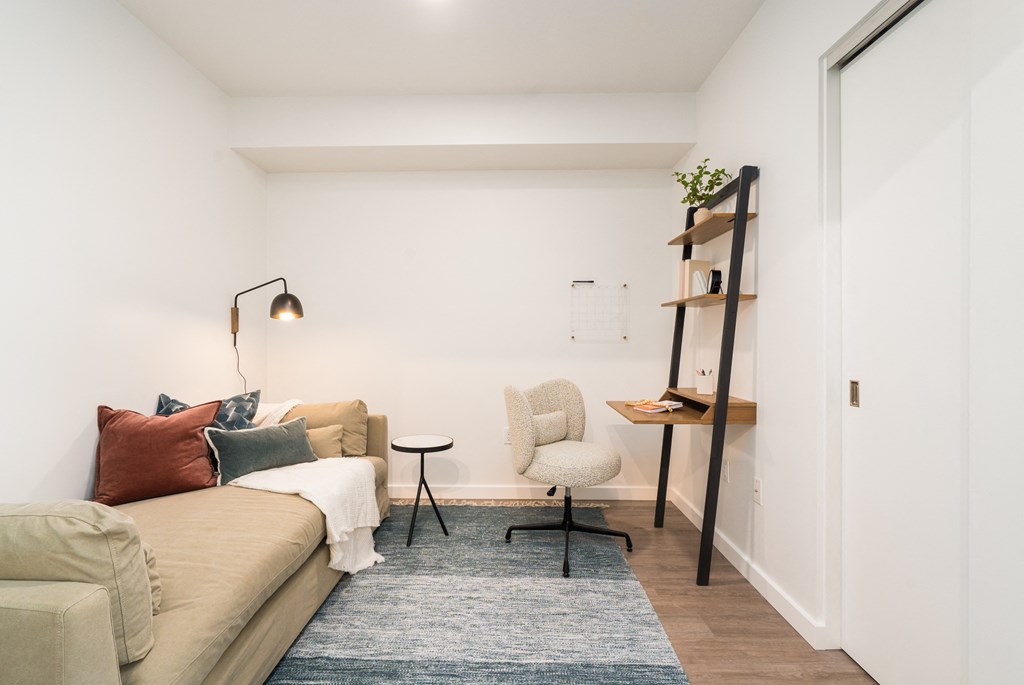 a living room with white walls and a beige couch