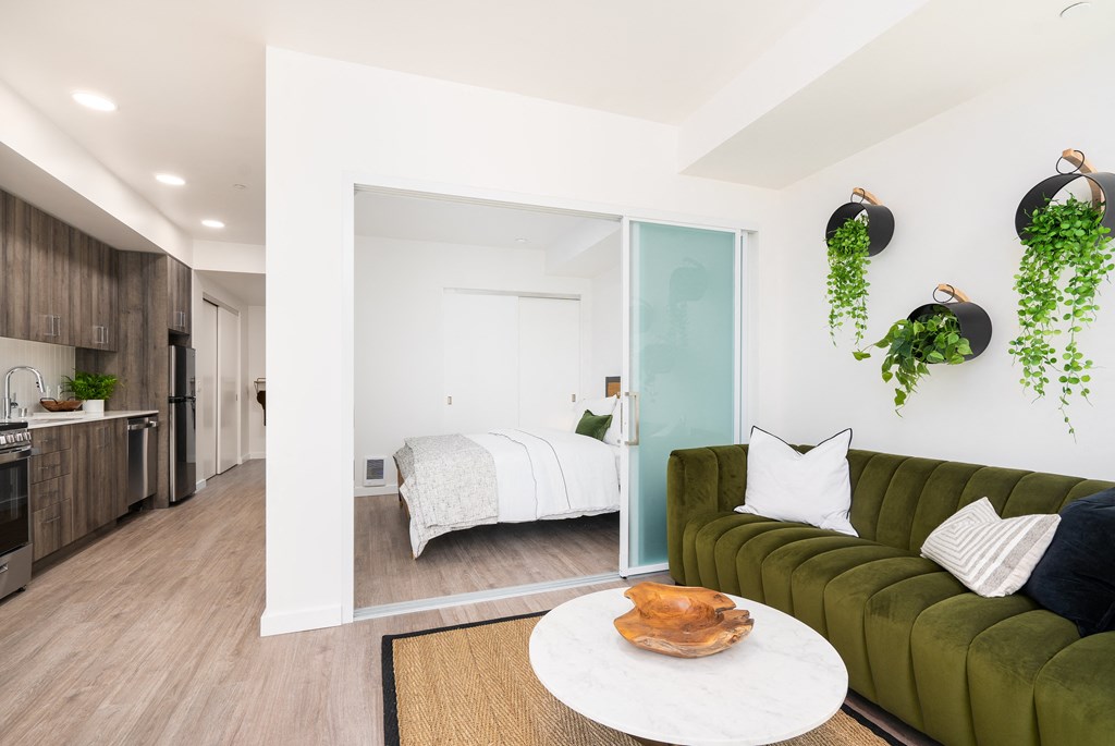 a living room with a green couch and a white coffee table