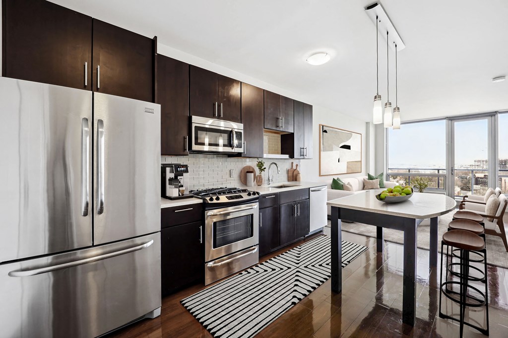 a kitchen with dark wood cabinetry and stainless steel appliances