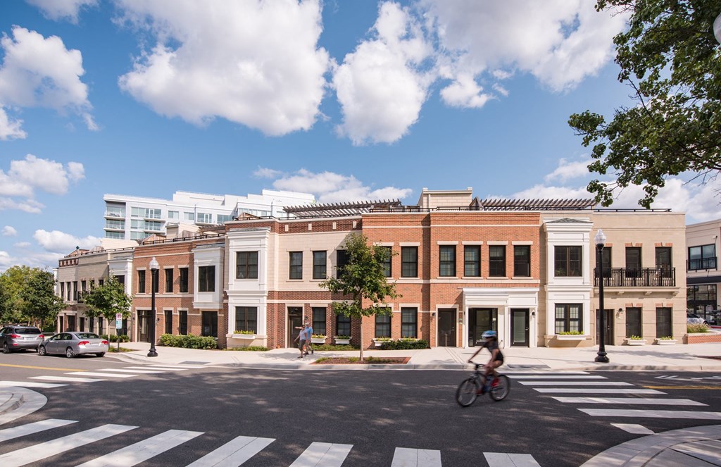 a man riding a bike down a street in front of a building