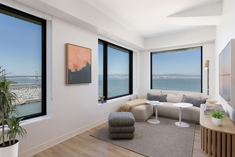 a living room with a couch and a table and some windows