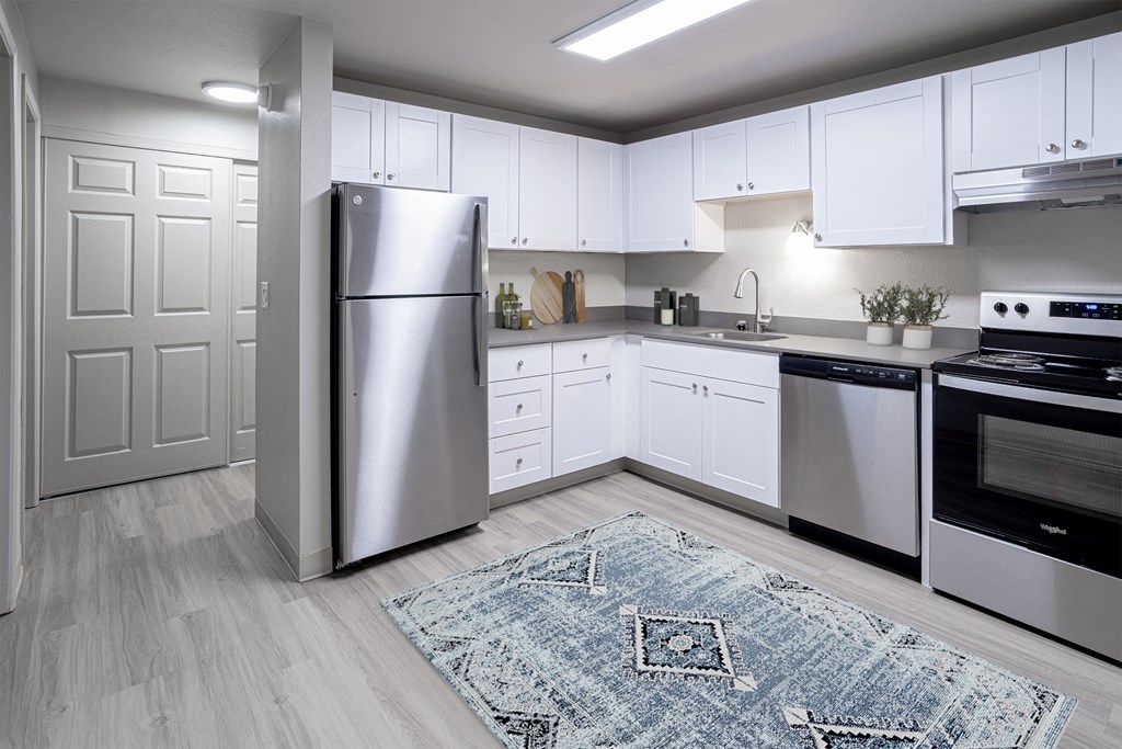 Kitchen with white cabinets and stainless steel appliances and a rug at Veri at Timberhill, Corvallis, 97330