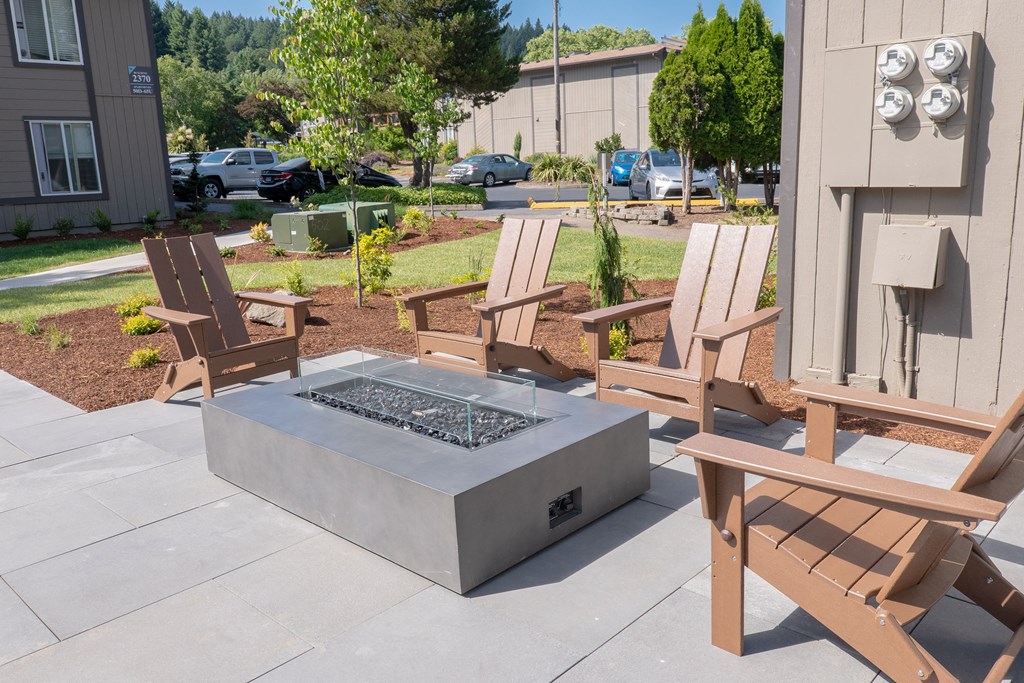 a firepit with two chairs around it and a parking lot in the background at Timberhill, Corvallis, OR, 97330