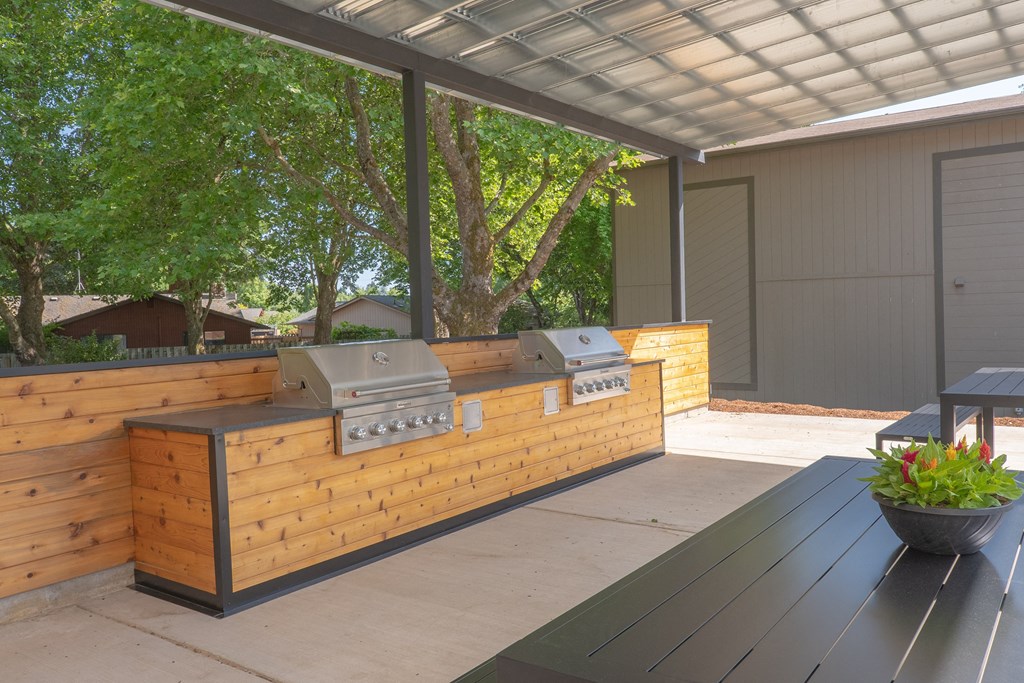 an outdoor kitchen with a wooden facade and a wooden table with a potted plant  at Veri at Timberhill, Corvallis, 97330