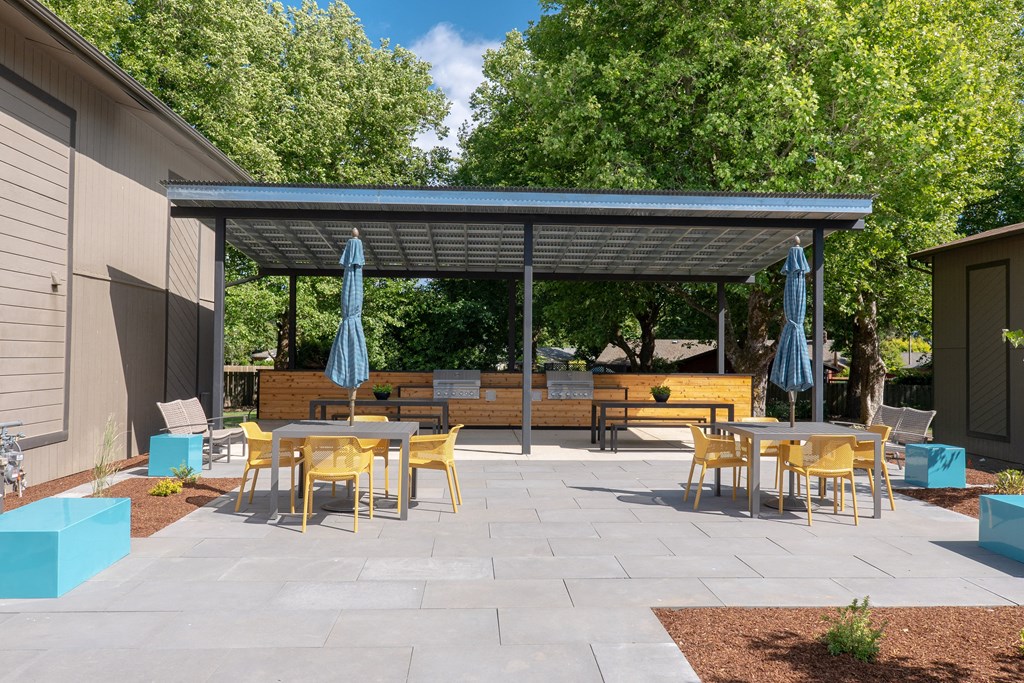 a patio with tables and chairs and awnings at Timberhill, Corvallis, 97330