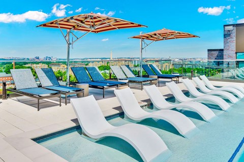 A pool area with sun loungers and plus seating near DCA. Rooftop Pool | 113 Potomac Ave SW Washington, DC 20024