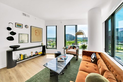 A living room with a black coffee table and orange couch.