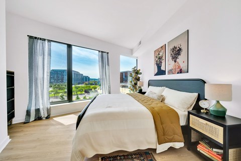 A bedroom with a large bed and a view of the city.