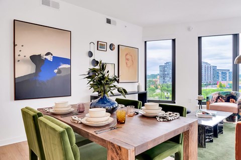A dining room with a wooden table set for a meal.