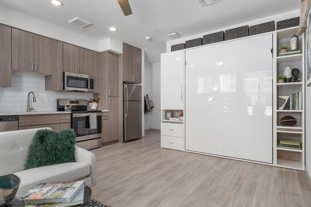 a kitchen and living room with white appliances and wood floors