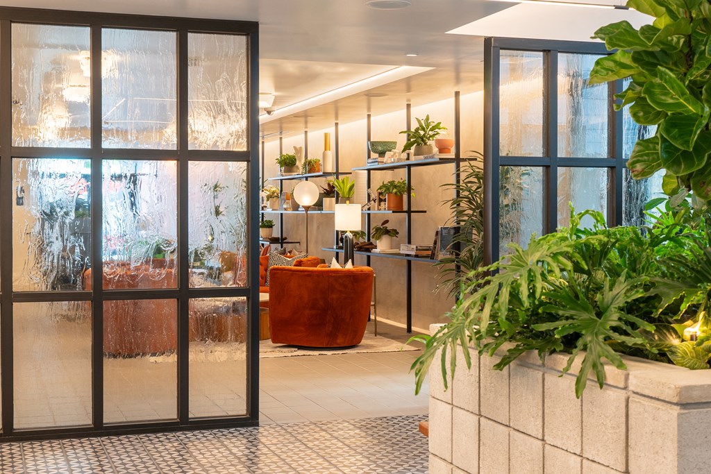 a room with glass doors and a large planter with plants