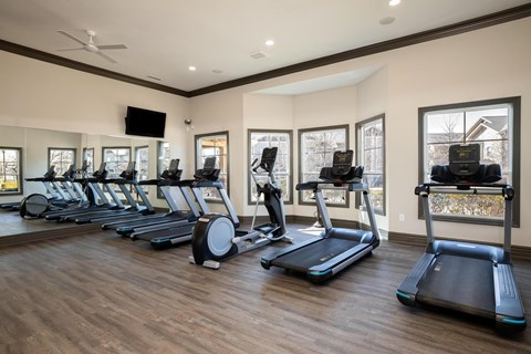 A gym with treadmills and elliptical machines.