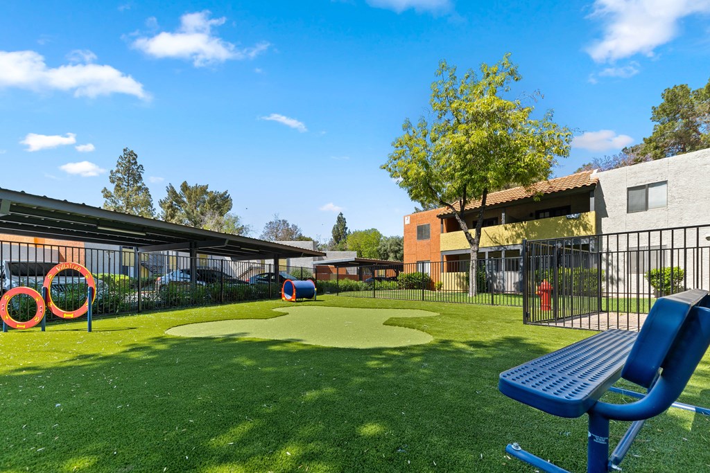 a blue picnic table sits in the middle of a grassy area with a mini golf course