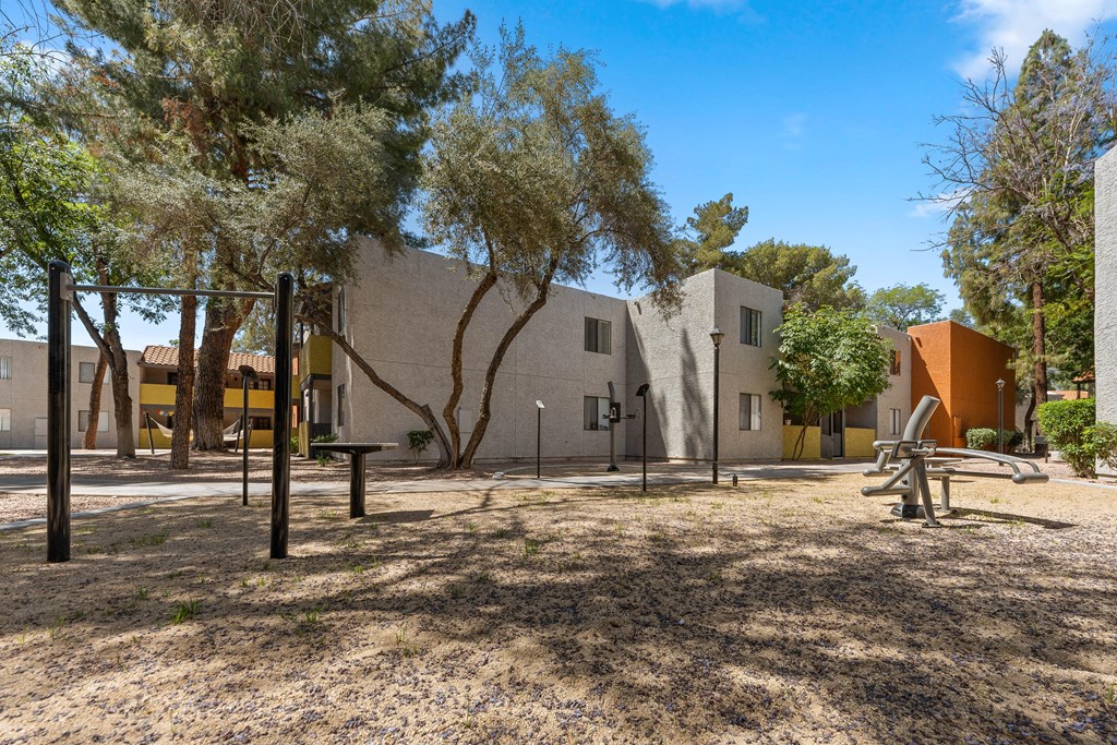 a park with a playground and trees in front of a building