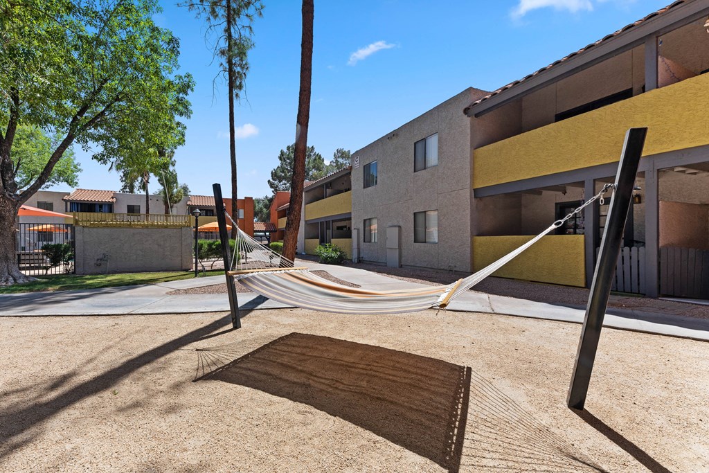 a hammock is hung on a pole in a courtyard at the whispering winds apartments in pear