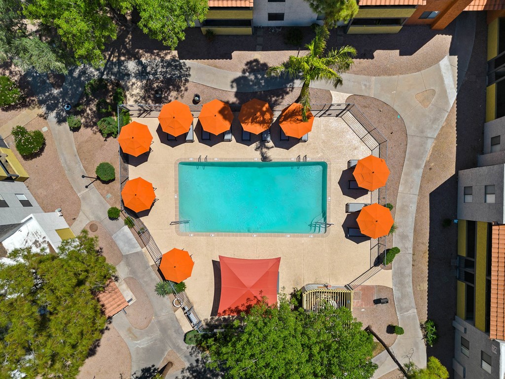 arial view of a swimming pool with orange umbrellas and a red tent
