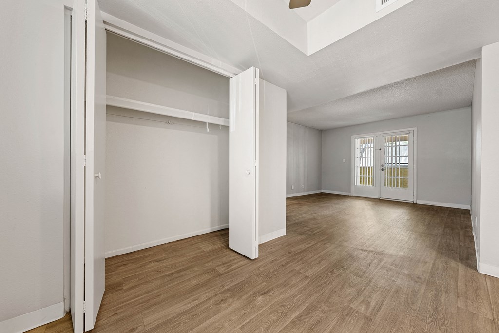 a bedroom with hardwood floors and white walls