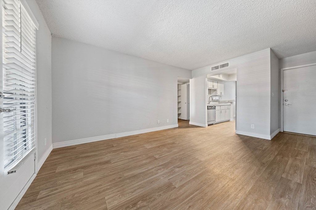 a bedroom with a hardwood floor and white walls