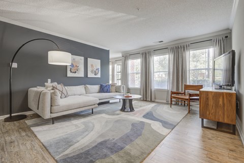 A living room with a grey couch and a wooden cabinet.