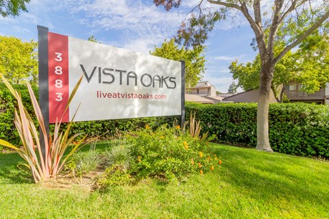 A sign for Vista Oaks with a website listed on it.