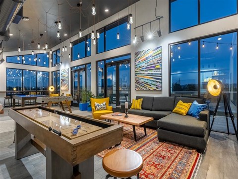 a living room with a pool table and glass windows