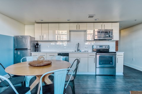 A kitchen with a table and chairs.