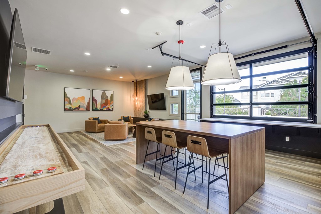 a kitchen and living room with a wooden table and chairs