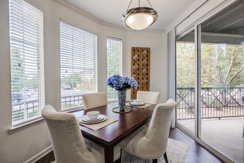 a dining room with large windows and a table with chairs