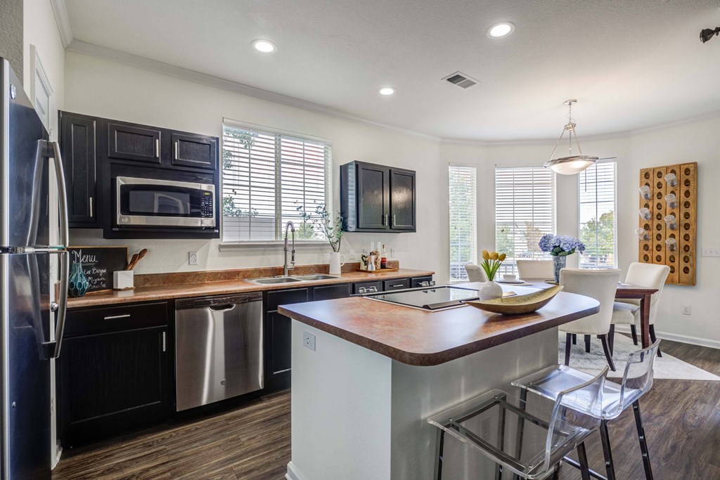 a kitchen with a large island and stainless steel appliances
