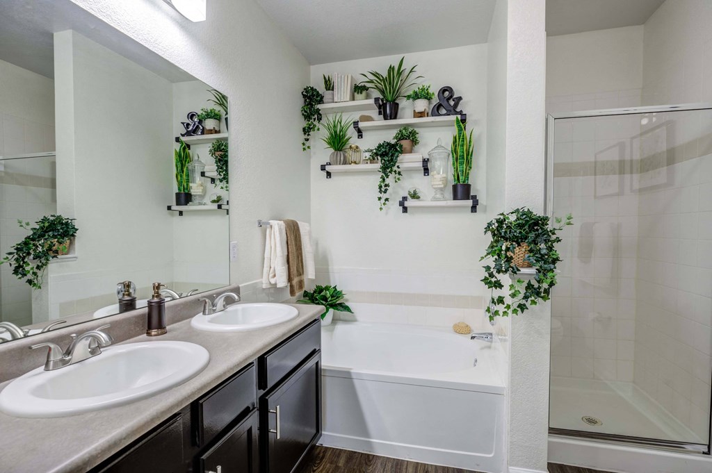 a bathroom with two sinks and a tub and a shower