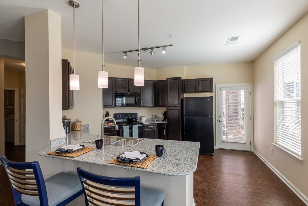 a kitchen with black appliances and a granite counter top