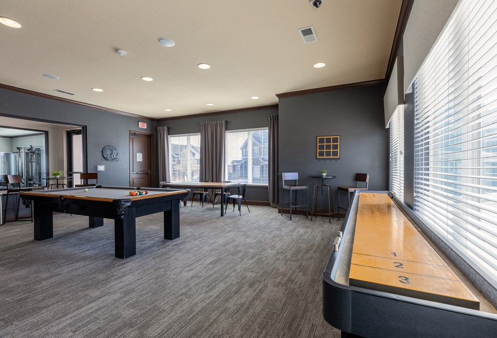 a game room with a pool table and a shuffleboard