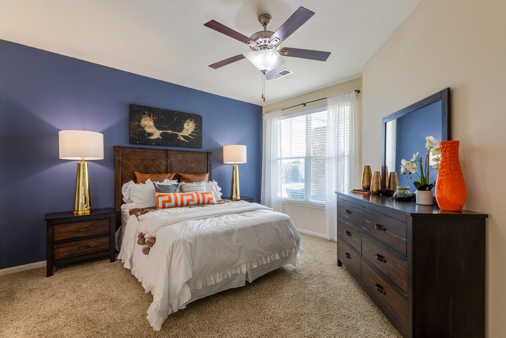 a bedroom with a bed and a ceiling fan
