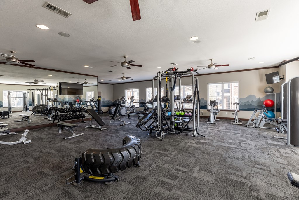 spacious gym with cardio machines and weights at the enclave at woodbridge apartments