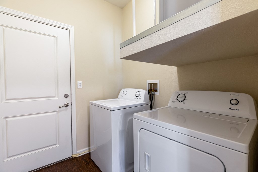 a laundry room with a washer and dryer and a door to a closet
