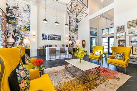 a living room with yellow chairs and a table