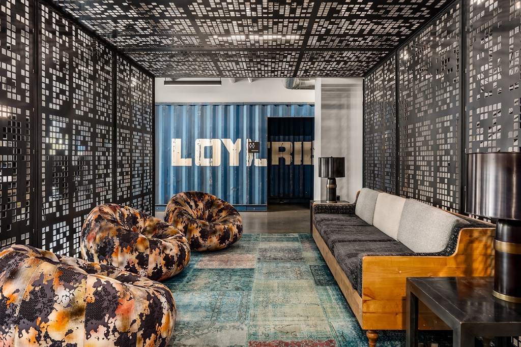 a living room with couches and chairs and a large screen on the wall