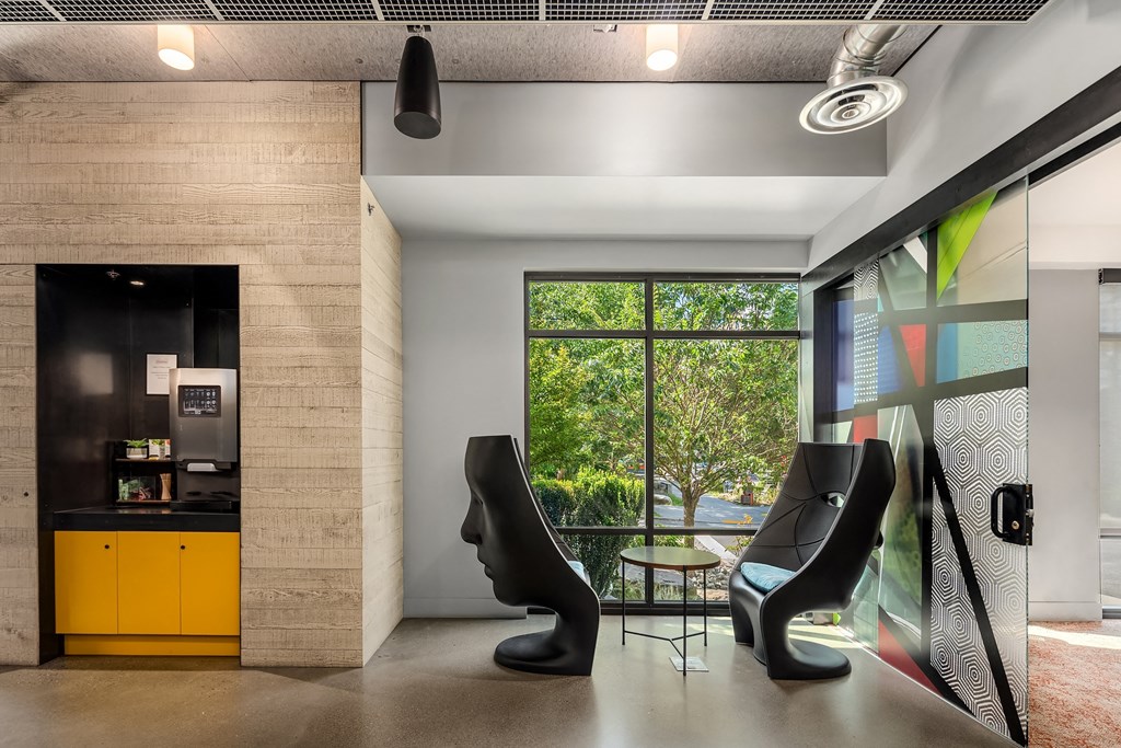 a room with two black chairs in front of a large window