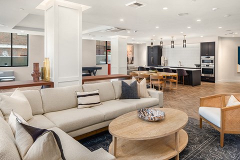 a living room and kitchen with couches and a table