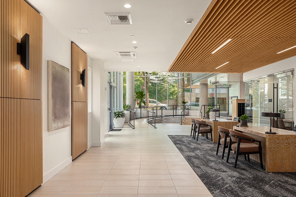 a long corridor with tables and chairs in a lobby