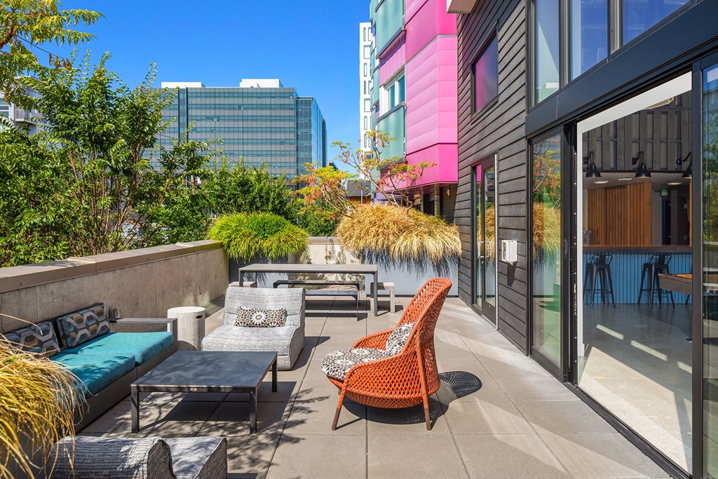 an outdoor patio with chairs and tables and buildings in the background
