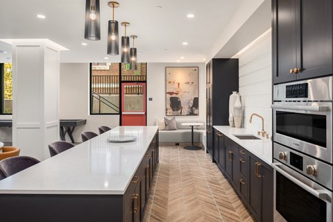 a kitchen and living room with black cabinets and white counter tops